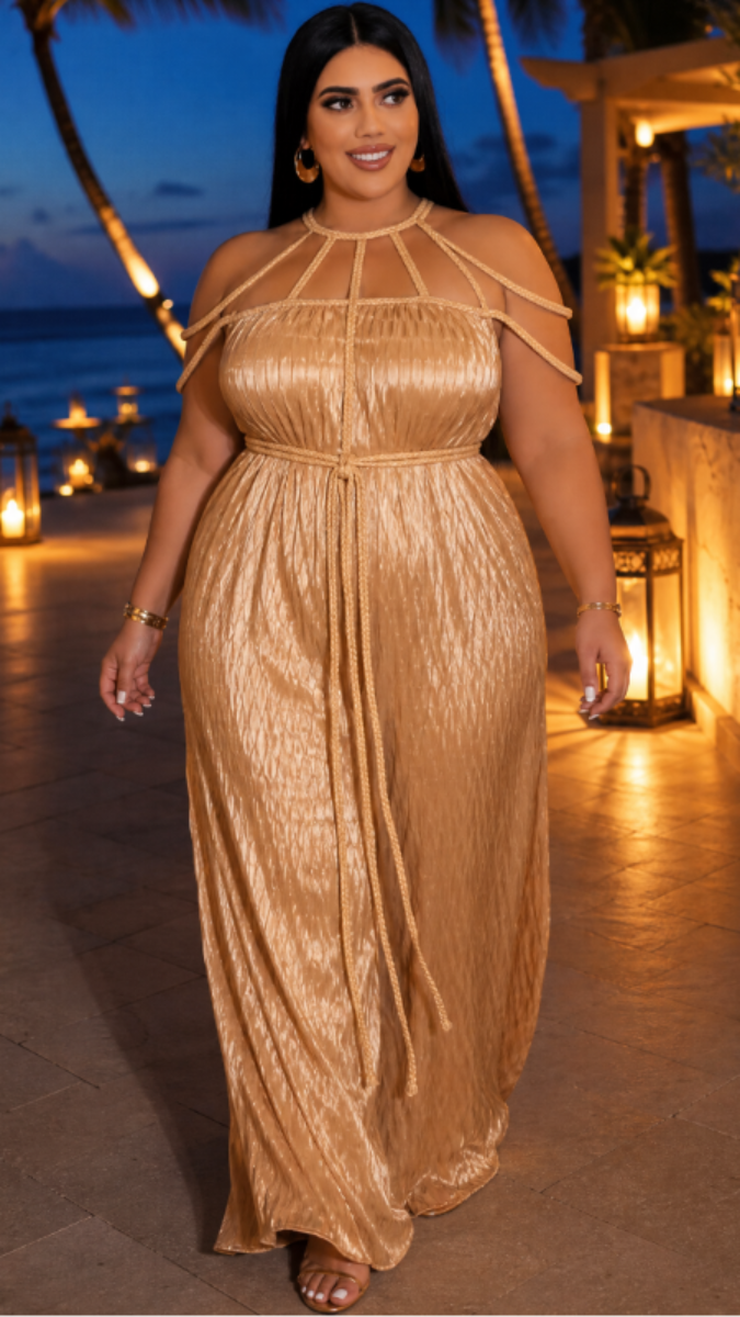 Woman in a gold dress standing on a beach at night with palm trees and lanterns.